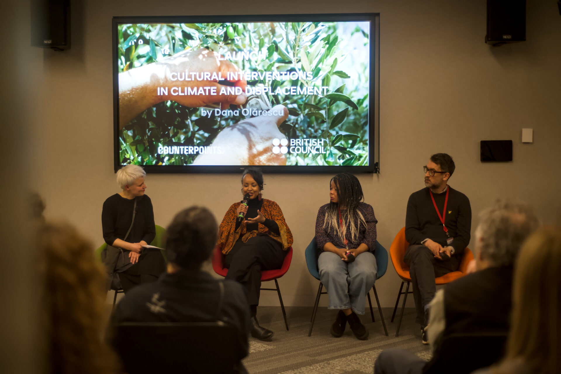 A group of people having a panel discussion at the launch of a paper on climate and displacement